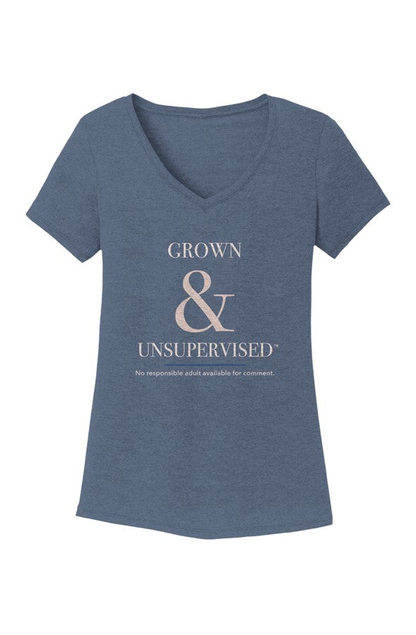 Navy Frost heathered navy women's V-neck tee, front view, with Grown & Unsupervised™ in ivory serif lettering, an oversized rosy-champagne ampersand, a thin royal-blue rule, and the line No responsible adult available for comment.