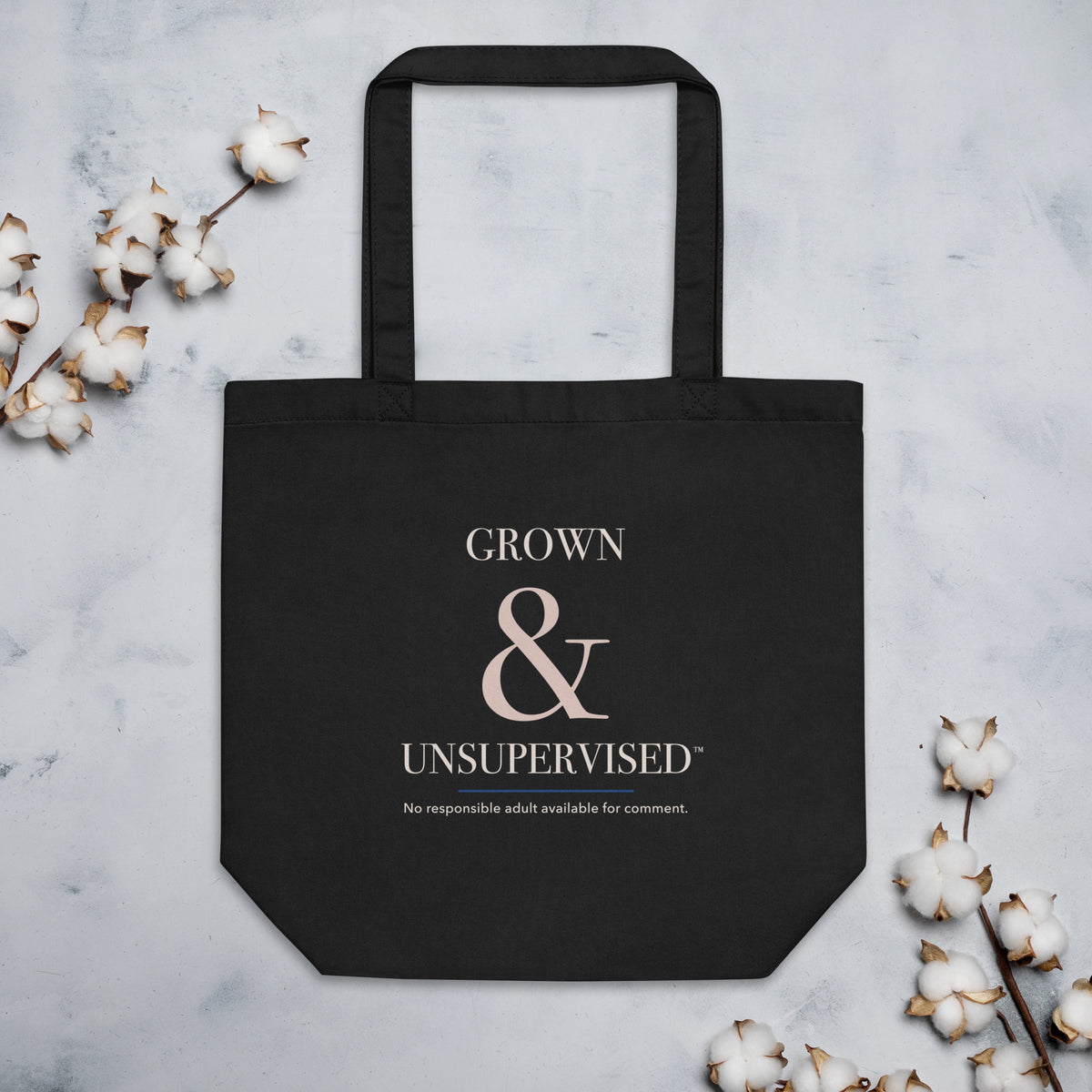 Black Grown & Unsupervised™ organic-cotton tote in a styled flat-lay.